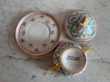 two cups and a saucer sitting on a marble table