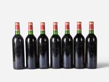 six bottles of wine lined up in a row on a white surface