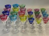 several different colored wine glasses sitting on top of a white table