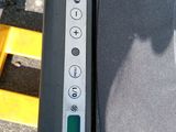 a close up of a parking meter with a car in the background