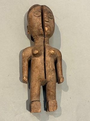 une vieille figurine en bois représentant un homme au visage abîmé