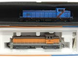 un train bleu et orange dans une boîte posée sur une surface blanche