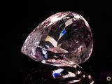 gros plan d'un diamant rose sur une surface noire