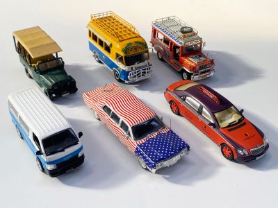 plusieurs petites voitures sont alignées sur une surface blanche