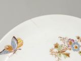 a plate with a butterfly and flowers painted on it