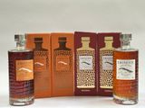 trois bouteilles de whisky posées l'une à côté de l'autre sur une table