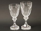 two empty wine glasses sitting next to each other on a table