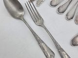 a lot of silver spoons and spoons on the table