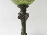 an antique green glass lamp with a crown on top of it