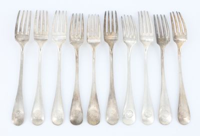 six fourchettes sont alignées en rangée sur une surface blanche