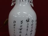 a white vase with asian writing on it on a red background