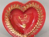petit plat rouge en forme de cœur, orné de feuilles d'or et portant l'inscription « Je t'aime »