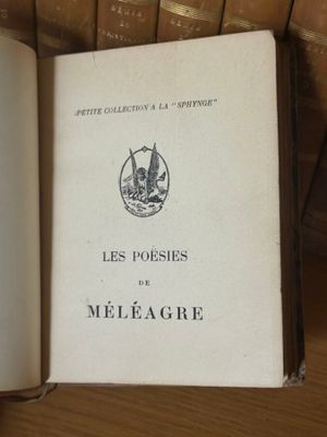 un livre ouvert sur une table, devant une rangée de livres