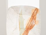 un bloc de marbre orange et blanc posé sur une table blanche