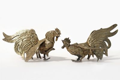pair of brass rooster figurines on white background with white background