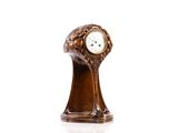 une horloge en bois posée sur une surface blanche