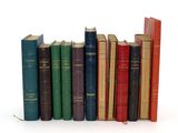 plusieurs vieux livres sont alignés sur une surface blanche