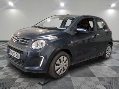 the small blue car is parked on a checkered tile floor