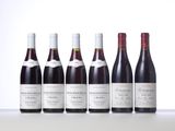 six bottles of wine are lined up on a table