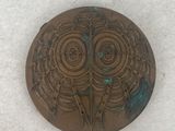 a small metal object with a design on it