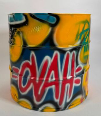 une canette recouverte de graffitis, posée sur une surface blanche
