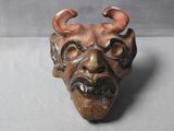 a ceramic sculpture of a demon head on a table