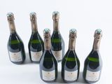 six bottles of champagne lined up in a row on a white surface