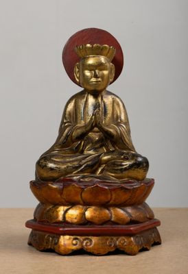 statue d'un Bouddha assis sur une fleur de lotus posée sur une table en bois