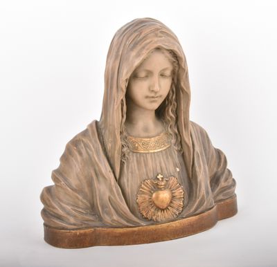 the statue of the virgin mary is holding a heart in her hands