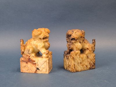 deux figurines de chiens sculptées sur un bloc de bois