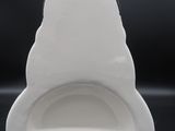 un vase blanc avec un socle noir posé sur une table noire
