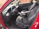 the interior of a red car with black leather seats and a steering wheel
