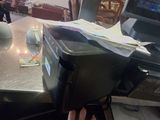 a person sitting at a table with a laptop and a printer