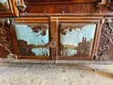 a wooden cabinet that has a painting on it