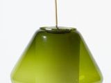 a green glass lamp with a white shade on it