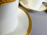 deux tasses et soucoupes posées sur une table, à côté d'une assiette