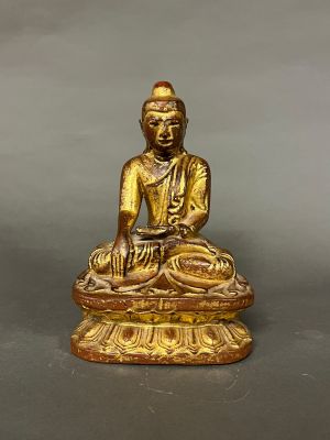 une statue en or représentant une personne assise sur une table