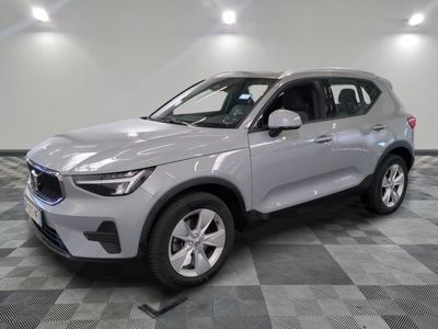 Le SUV argenté est garé dans une grande pièce au sol en damier.
