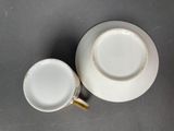 a white cup and saucer sitting on a table
