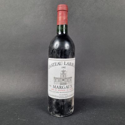 an old bottle of wine sitting on top of a table