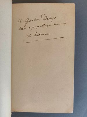 un livre ouvert, sur lequel on peut lire une inscription manuscrite, posé sur une table