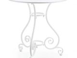 La table est blanche et possède un piètement en métal.