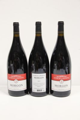 three bottles of red wine are lined up on a white surface