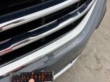 a close up of a person ' s hand holding a book in front of a car