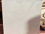an image of a white dishwasher sitting on top of a pink floor