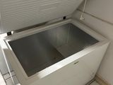 a white chest freezer sitting in the corner of a kitchen