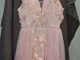 a dress hanging on a hanger in front of a wall