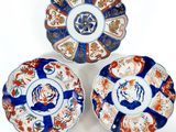 three plates with different designs on them sitting on a white surface