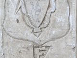 plaque en ciment représentant un trophée, apposée sur la façade d'un bâtiment