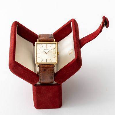 a watch sitting in a red box on a white surface